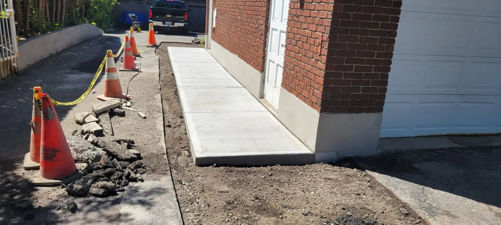 New concrete walkway beside a brick commercial building