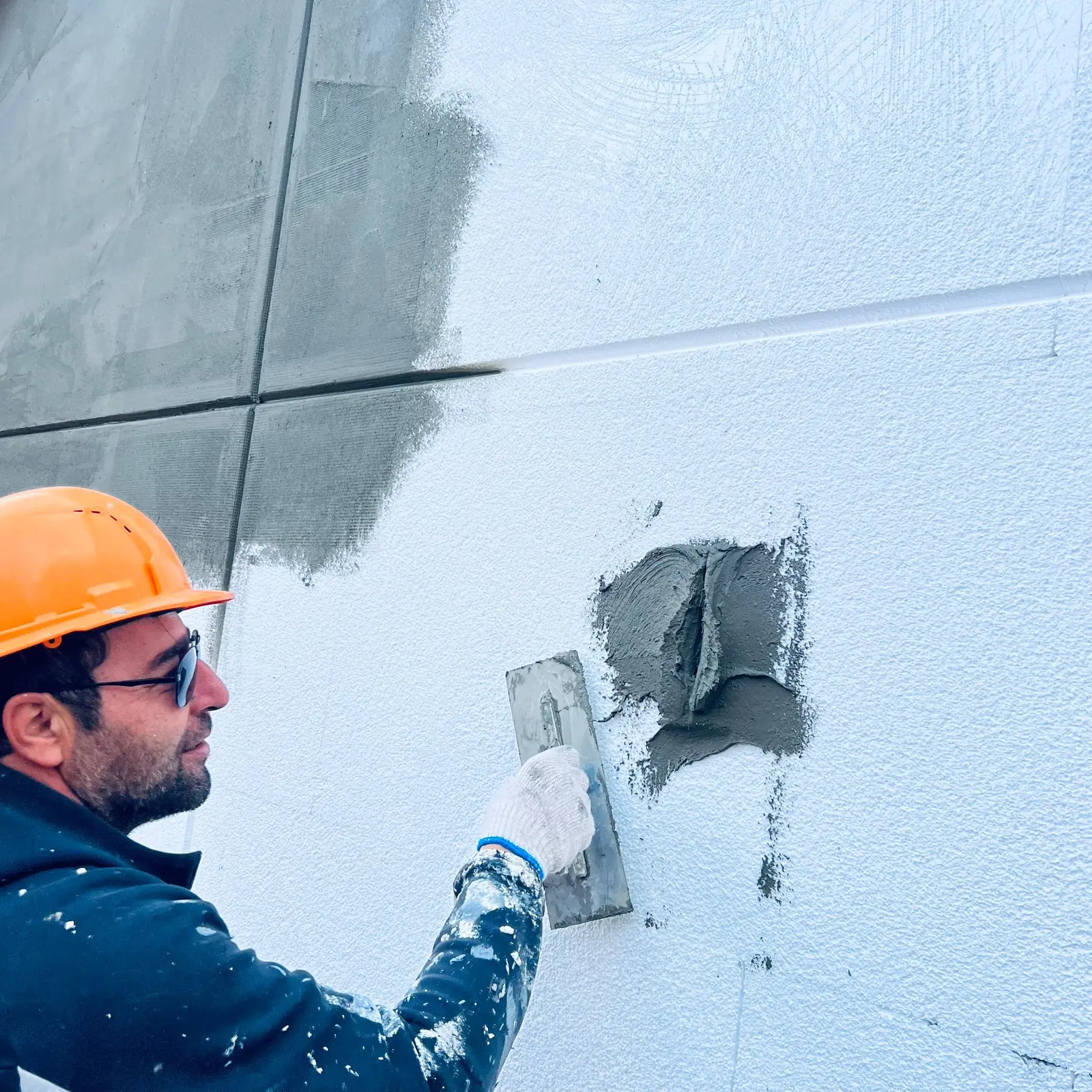Capital Craft Construction owner applying exterior finish by hand